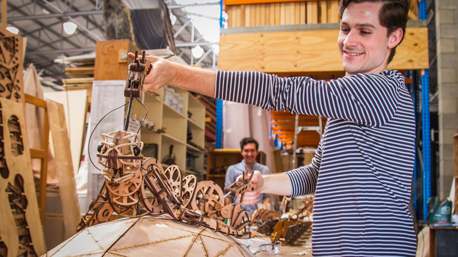 Nicholas Paine holding one of the wooden laser cut puppets the company uses.