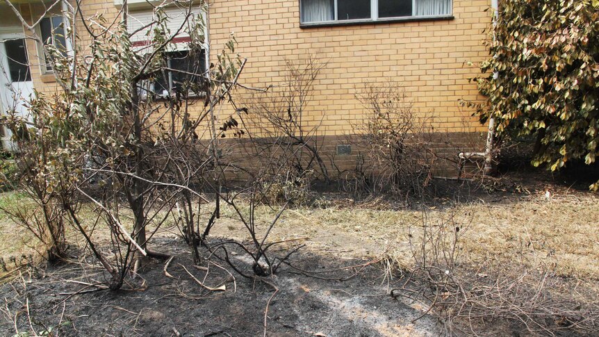 Brick farmhouse with burnt yard around the perimeter but no damage to building