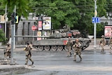 Soldiers in uniform stand near a tank in the streets of Rostov-on-Don