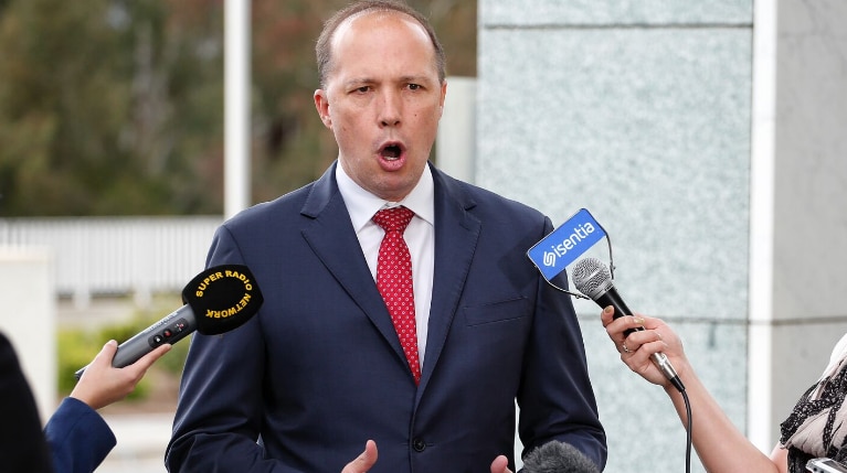 Immigration Minister Peter Dutton gestures and speaks to reporters at Parliament House.