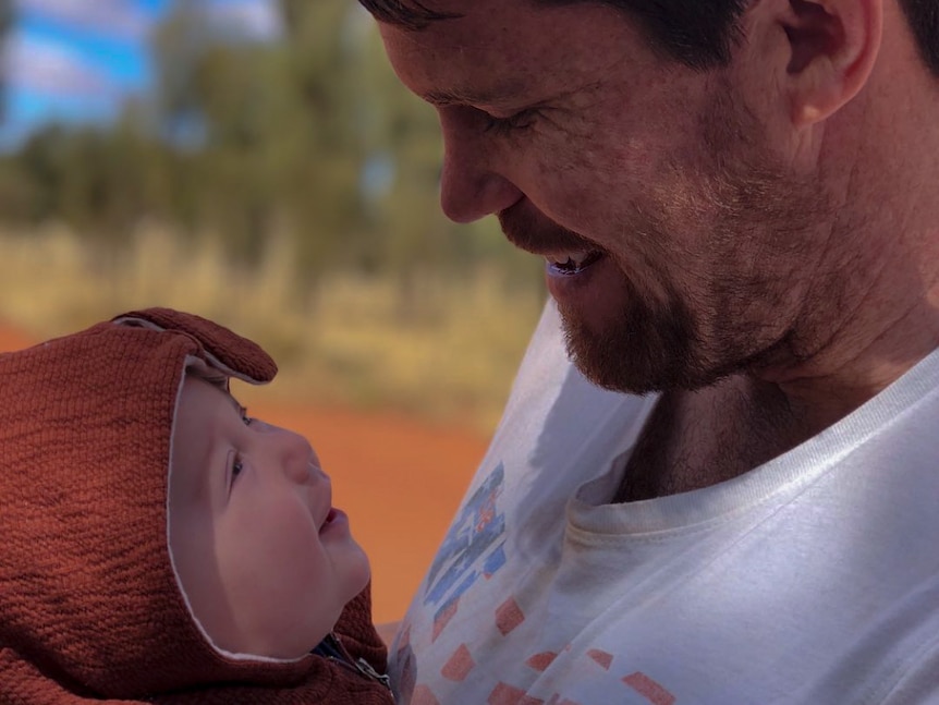 A close up of a man with a baby.