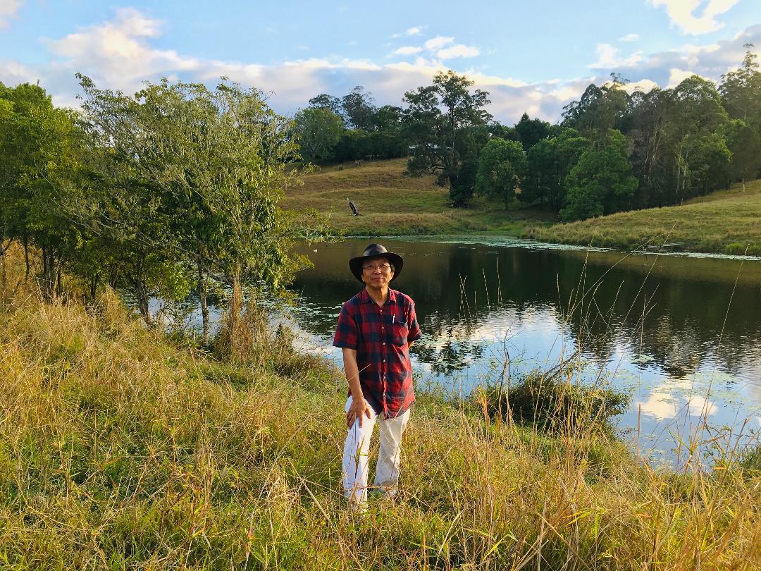 a man standing over behind a dam with water