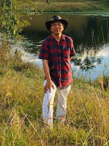 a man standing over behind a dam with water
