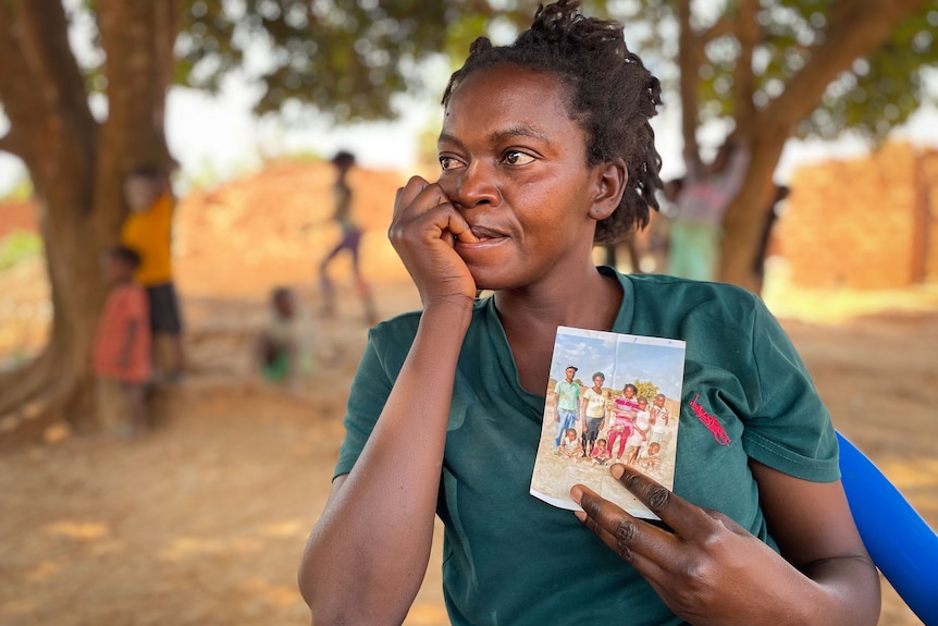 A woman holds a photograph.