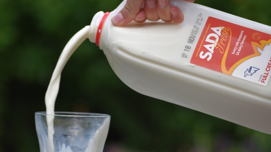 A two-litre bottle of SADA fresh milk being poured into a glass.