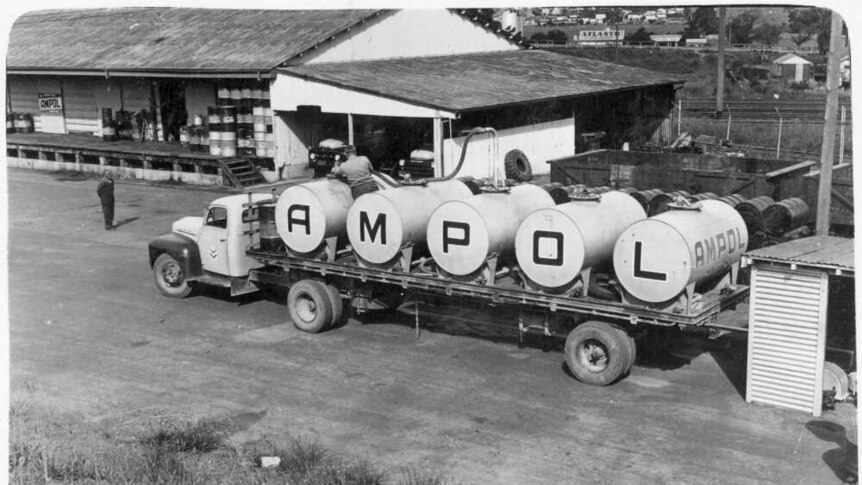 A truck with Ampol markings fills up at a depot in a black and white photo.