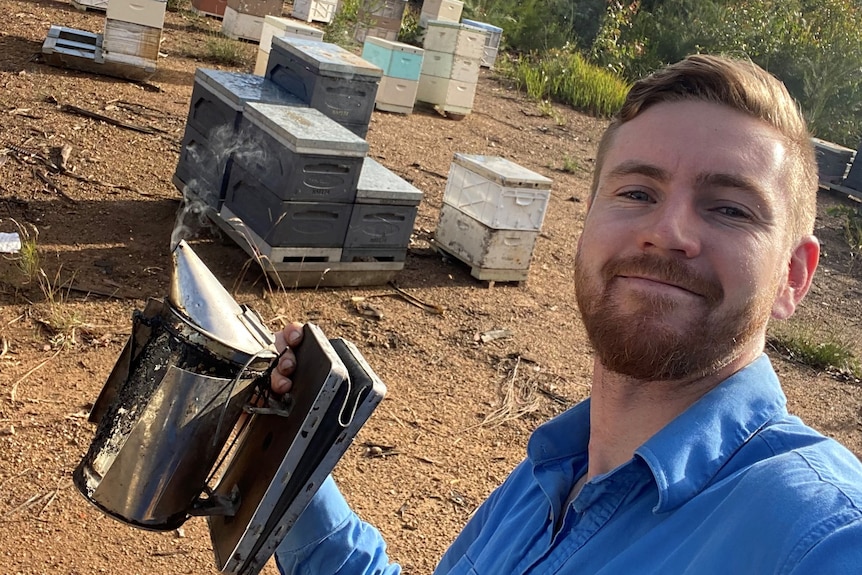 Man in front of beehives
