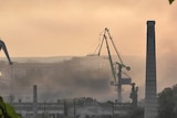 Smoke rises at a shipyard.