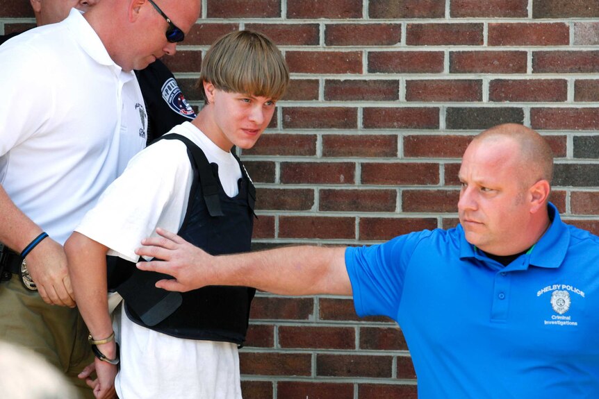 Police lead suspected shooter Dylann Roof into the courthouse