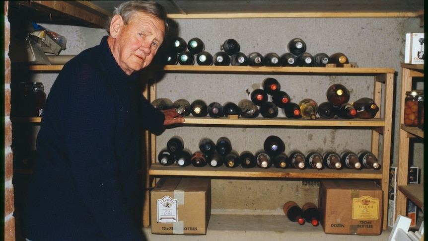 Former prime minister John Gorton poses for the camera in his wine cellar.