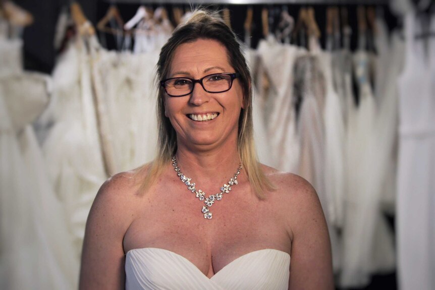 Debbie Clark in a wedding dress and diamond necklace.
