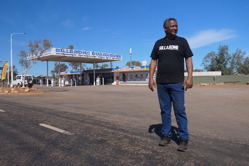 A man stands outside an almost deserted roadhouse