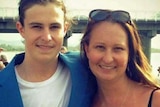 Mother and 21 year old son with his arm over his mum both smiling