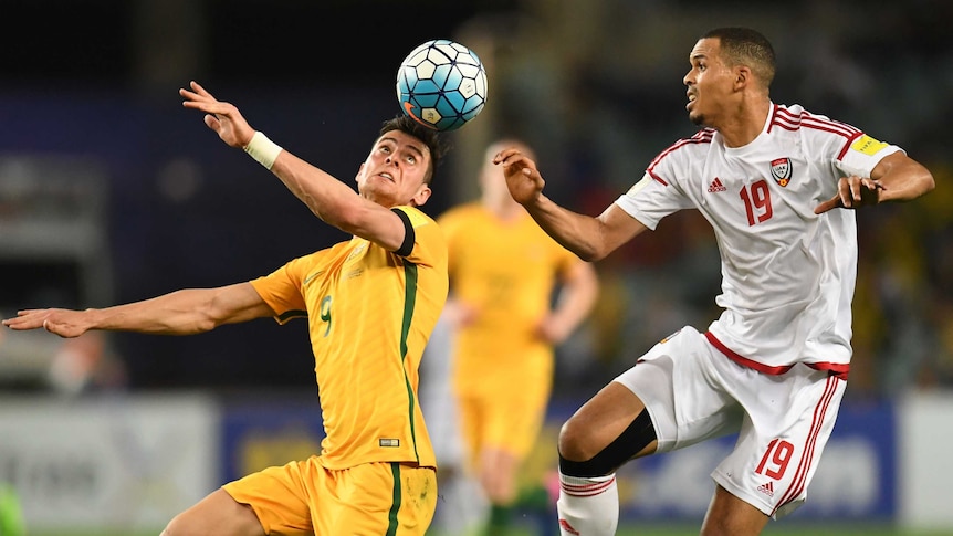Tomi Juric heads the ball while Ismail Ahmed looks on.