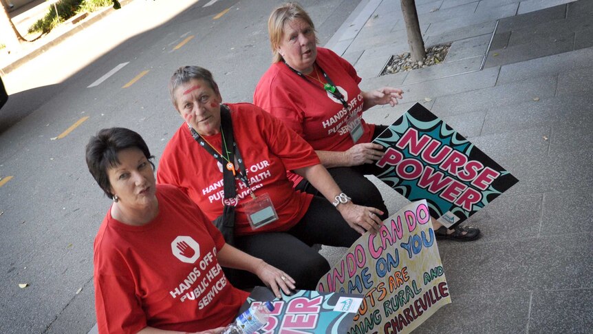 Queensland nurses take a break after a union march in Brisbane