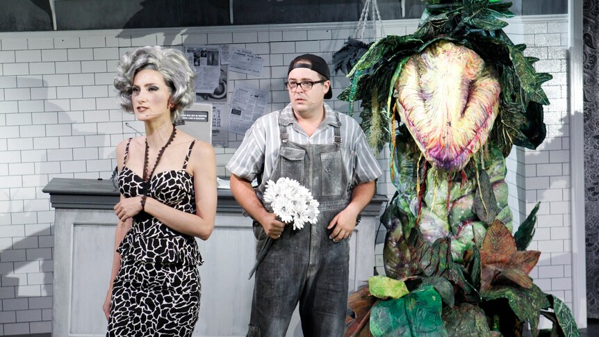 Production still showing Audrey and Seymour and carnivorous plant Audrey II in the background.
