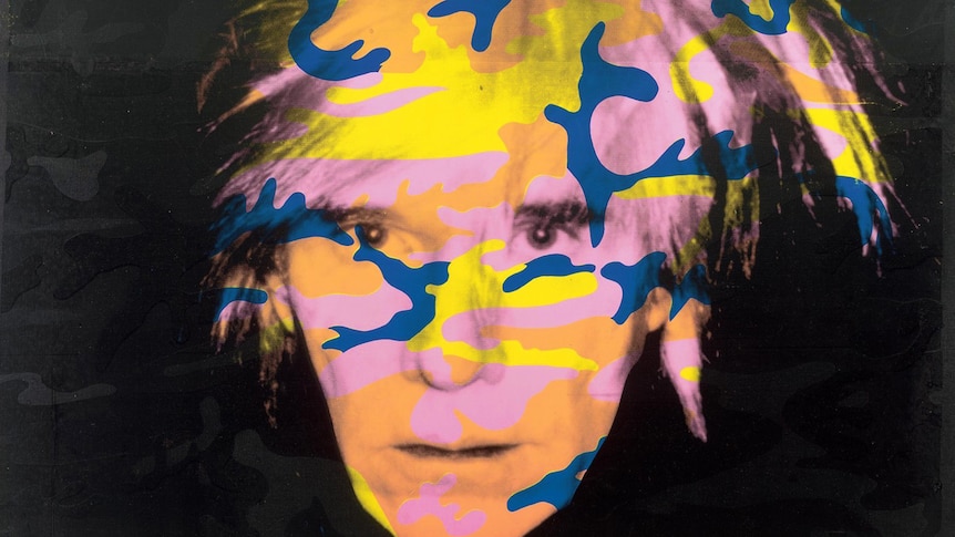 A photo of ANdy Warhol with colourful splotches drawn on.