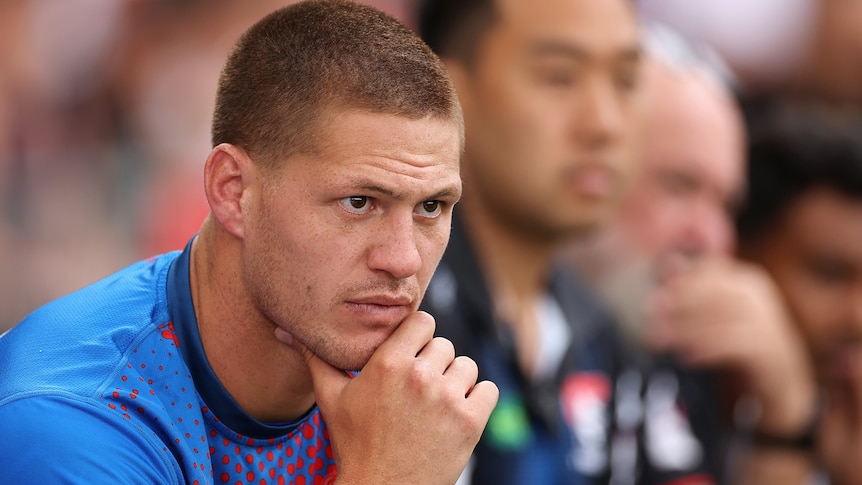 Kalyn Ponga sits on the sidelines during a Newcastle Knights NRL game.