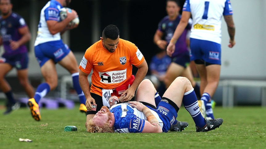 Injury scare ... James Graham receives attention from a Bulldogs trainer against the Storm