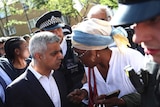 Said Khan speaks to a woman wearing a cream and blue headscarf at an event where he addressed a crowd of 300
