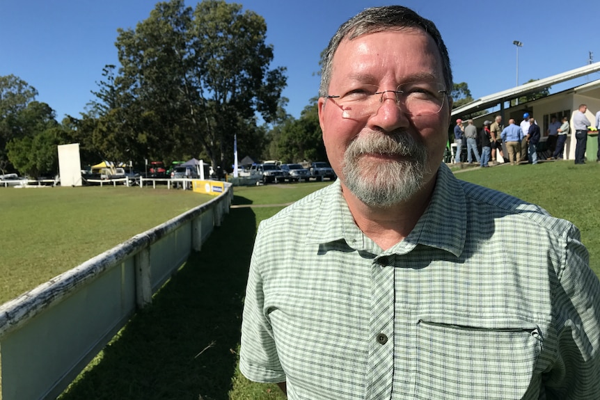 Dr Mike Smith looking at the camera with people standing in the background.