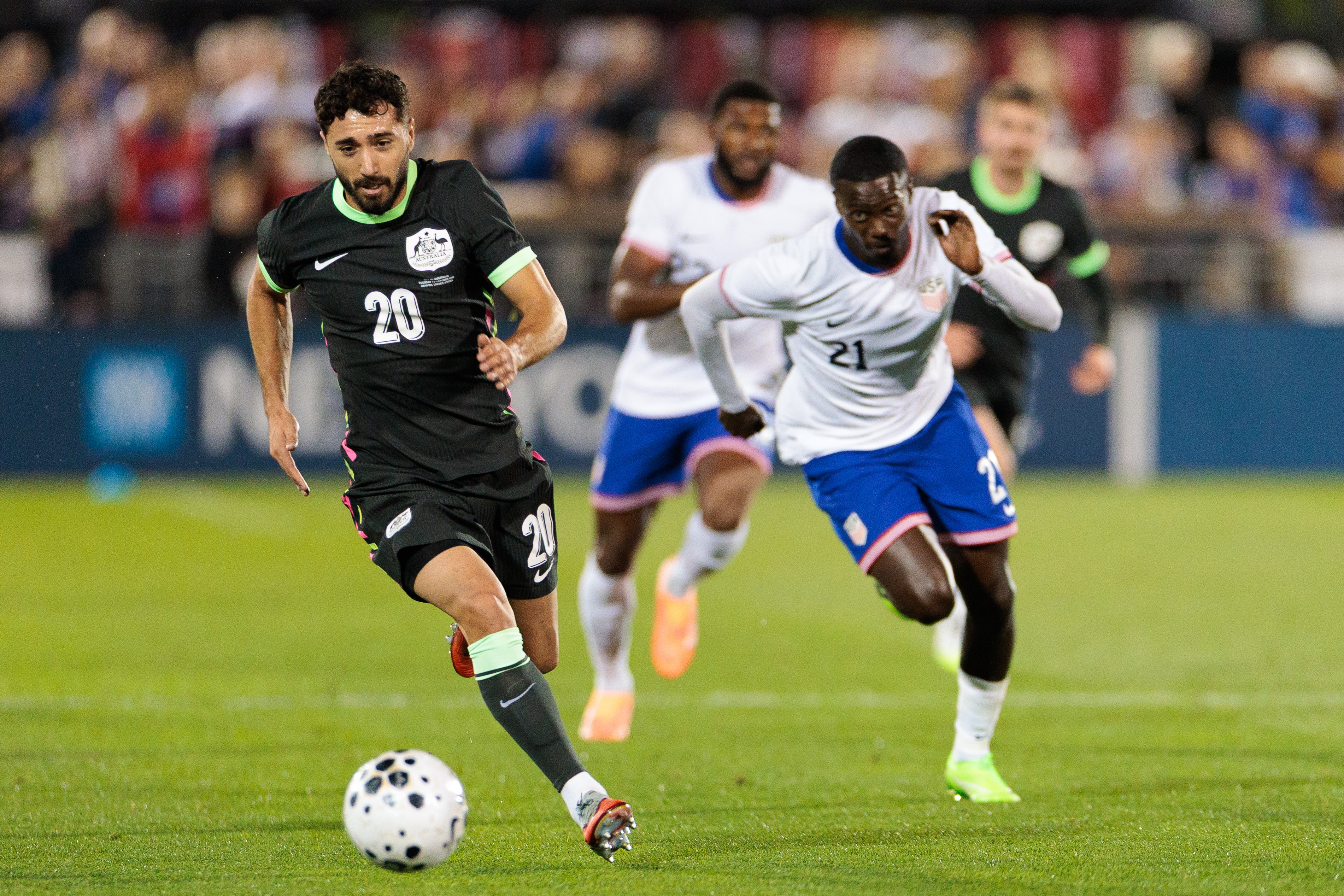O jogador do Socceroos, Jacob Italiano, corre com a bola durante um jogo.