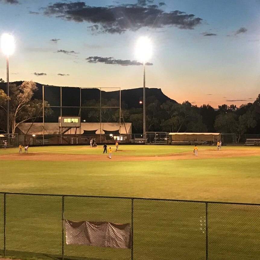 A desert baseball diamond where players play under lights.