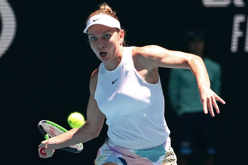 A female tennis player runs to play a forehand return at the Australian Open.
