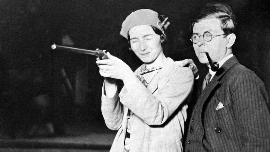 Simone de Beauvoir holding a gun, eyes closed, and Jean-Paul Satre with pipe in mouth.