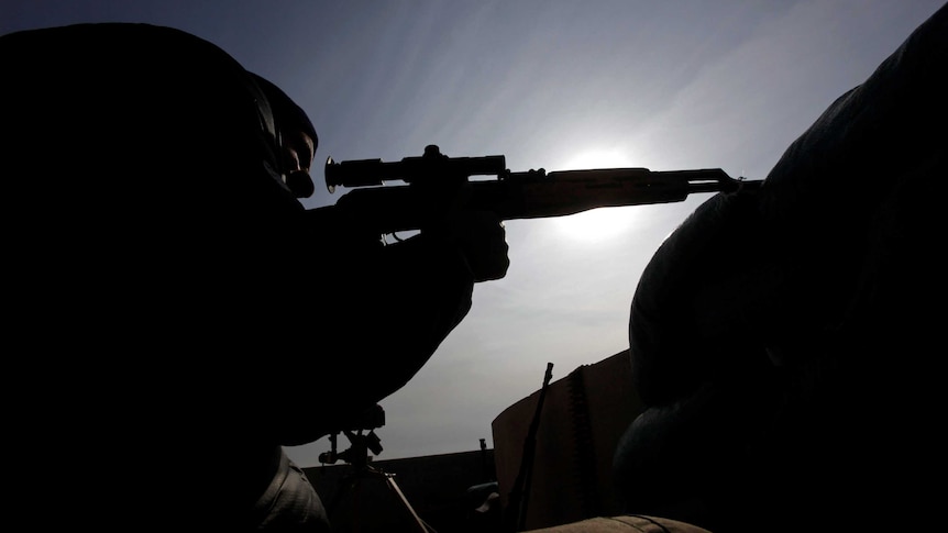 The silhouette of an Iraqi sniper from a low perspective looking up.