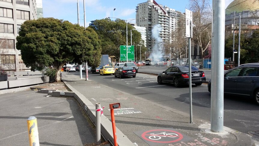 Smoke is seen coming from a tram after power lines come down on St Kilda Road.