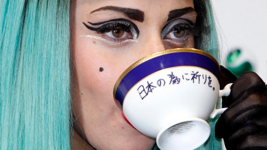 Lady Gaga, drinks from a teacup with the words 'Pray for Japan' written on it.