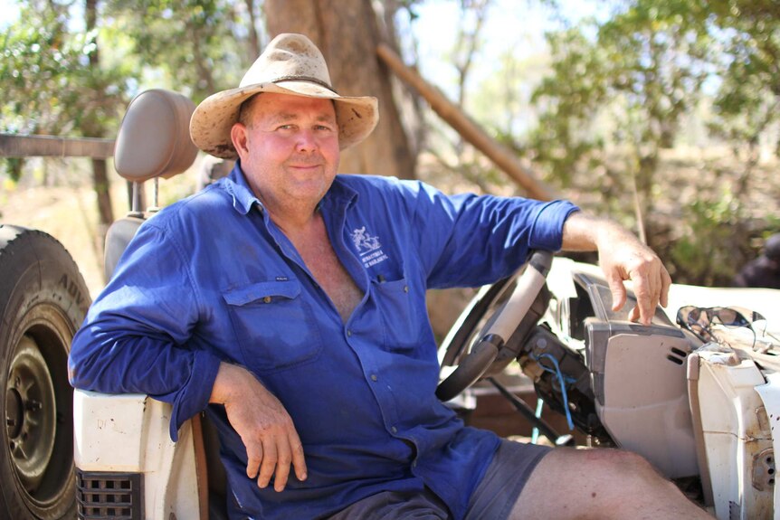 Jed Fawcett sitting in the driver's seat of a stripped-down jeep with no windscreen. He's wearing a blue shirt and beige hat
