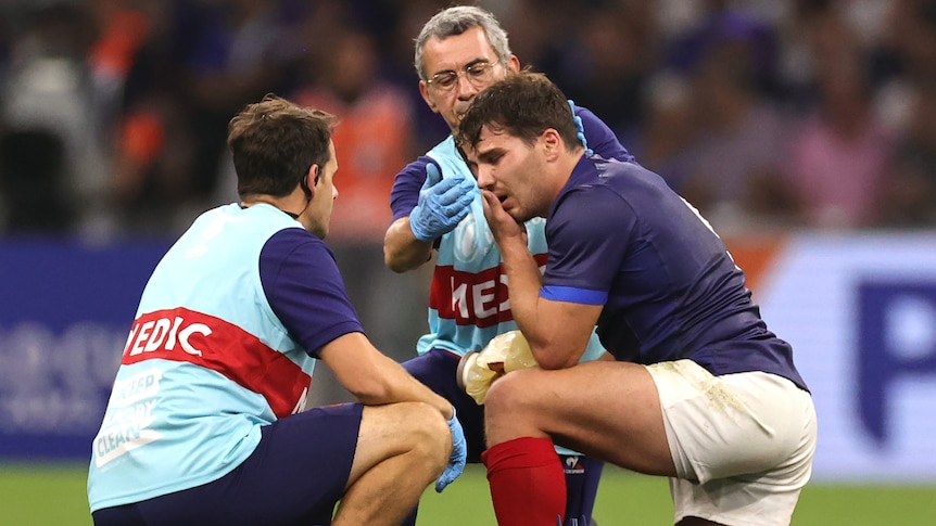 A French male rugby union player receives medical attention after being injury at World Cup.