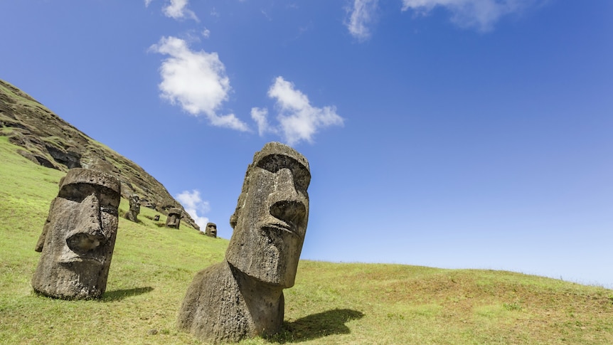 Two massive stone carved heads poking out of a hillside