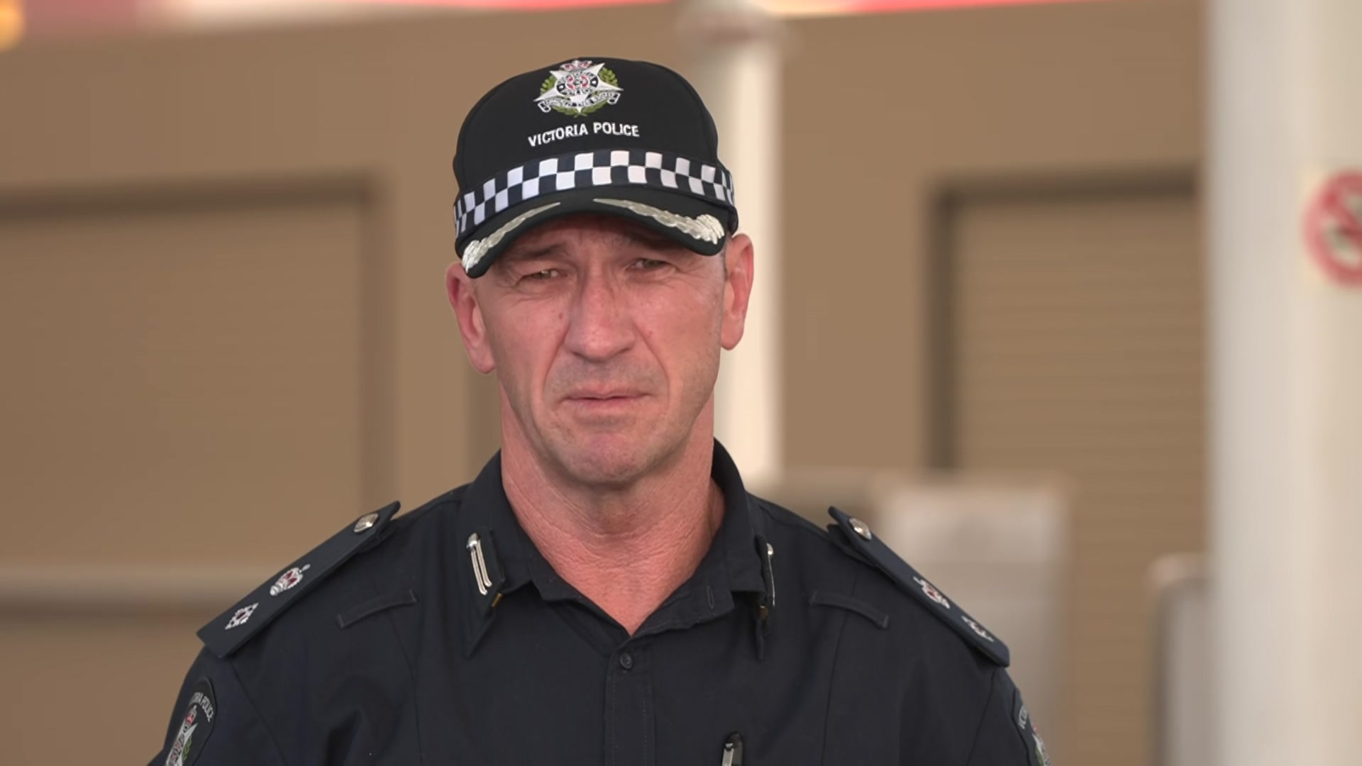 A policeman speaking to reporters at an airport
