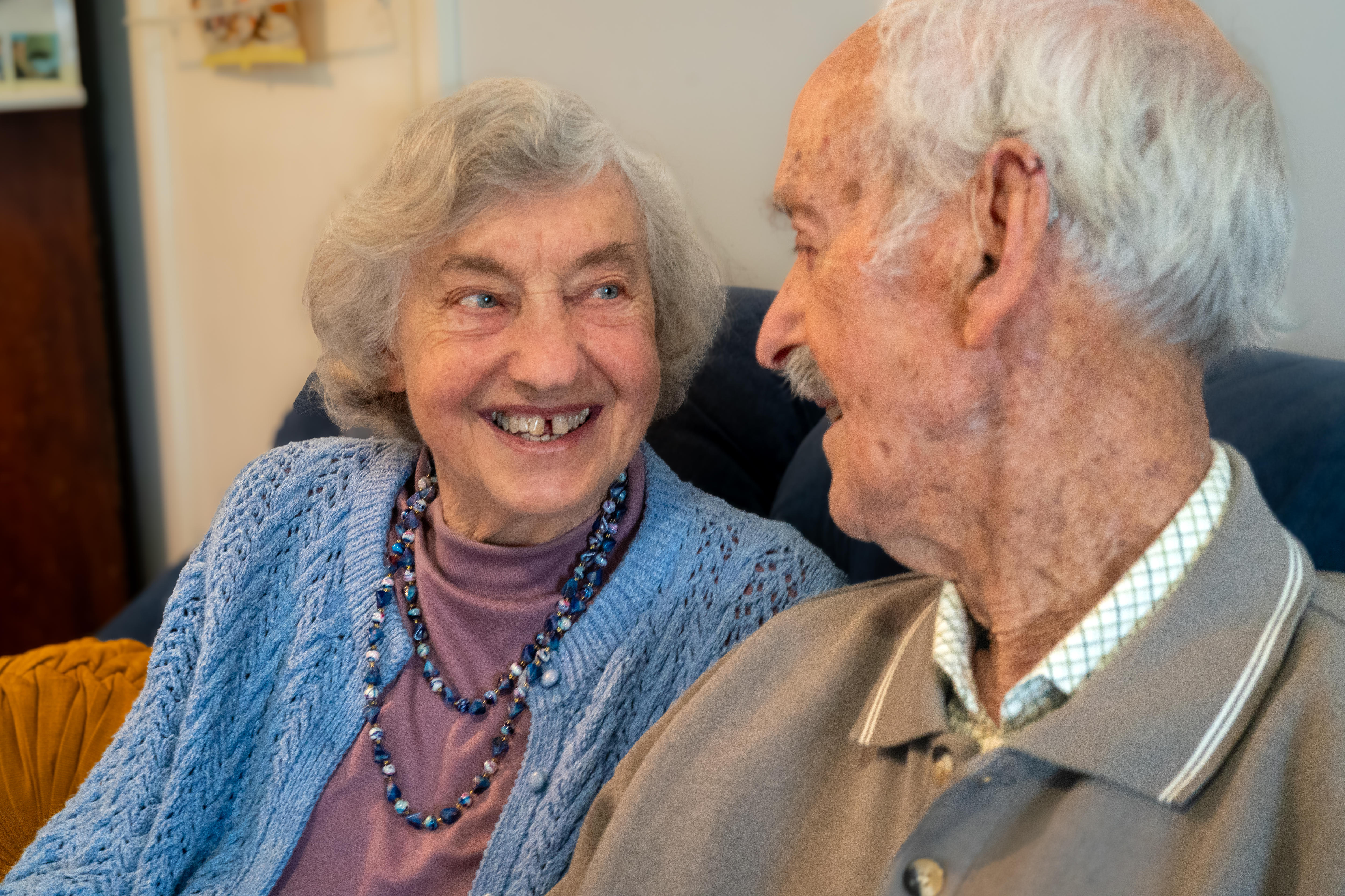 An elderly couple look lovingly at each other