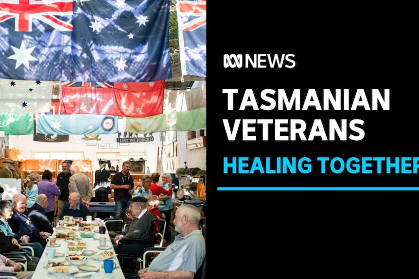 Tasmanian Veterans, Healing Together: A group of elderly people sit at a table under flags.