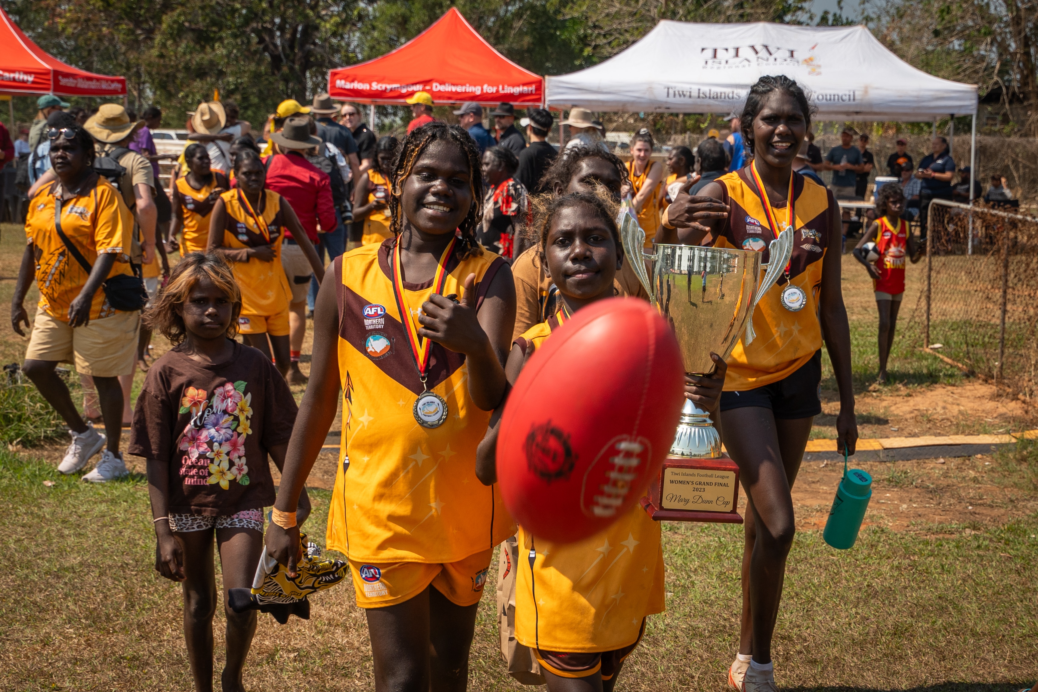 Young women playing with an AFL ball