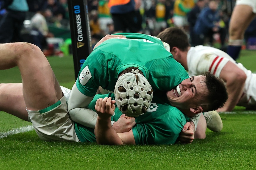 Dan Sheehan smiles as he is hugged while lying on his back