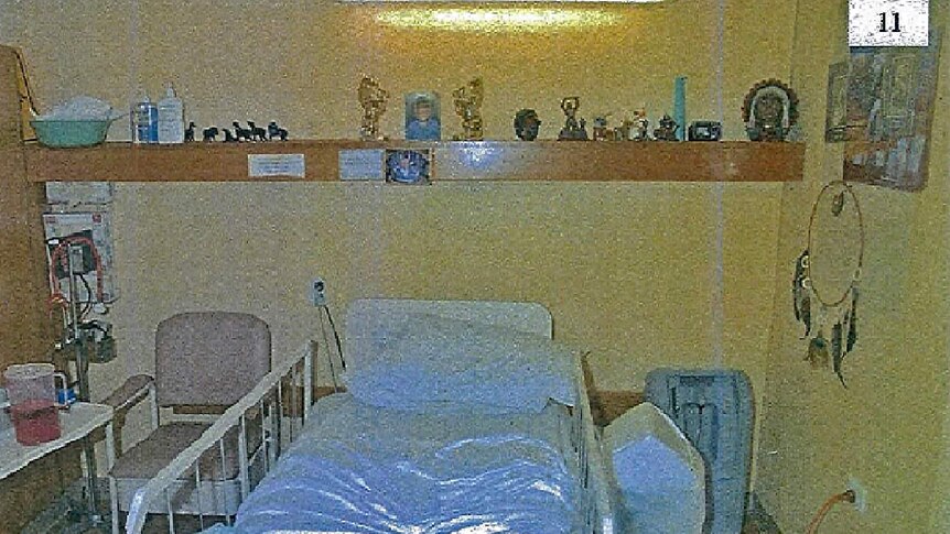 Oakden nursing home room with bed and shelf.
