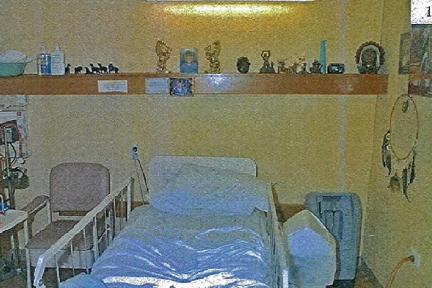 Oakden nursing home room with bed and shelf.