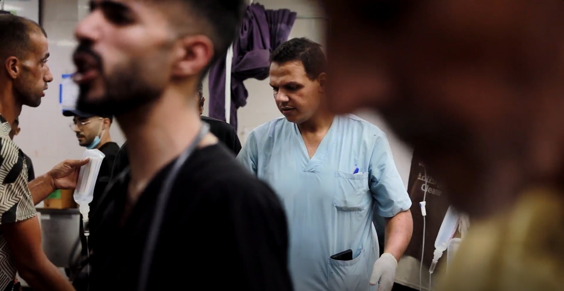 A doctor surrounded by several men in the foreground