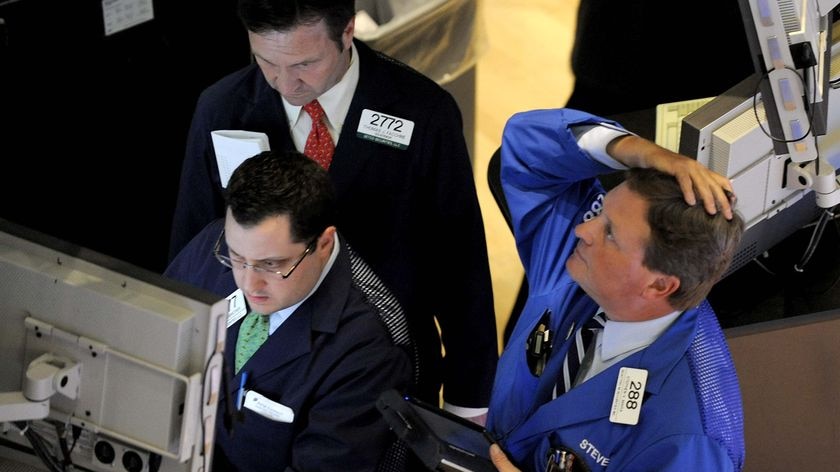 A trader on the floor of the New York Stock Exchange looks at stocks