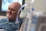 A middle-aged man receiving cancer treatment at a hospital