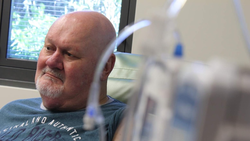 A middle-aged man receiving cancer treatment at a hospital