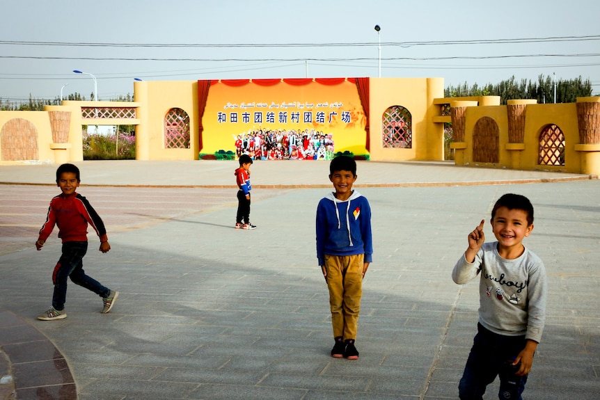 Children standing in front of  Uyghur village. 