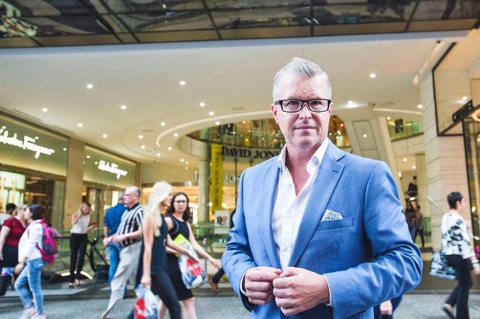 A man wearing suit in front af a store