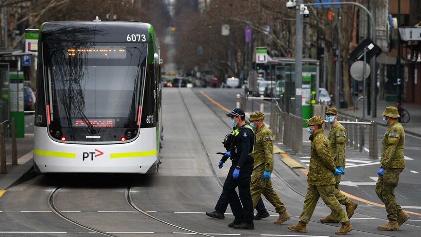 ADF personnel and police officers patrolling a deserted Bourke Street, Melbourne.
