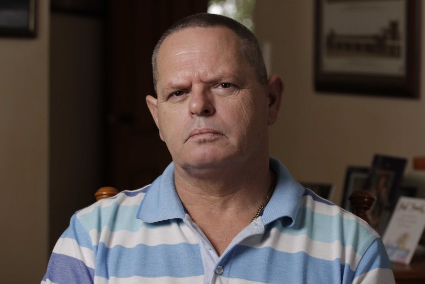 Greg Halloran wears a blue and white striped shirt